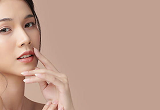 笑顔の女性が口元に手を当てている様子